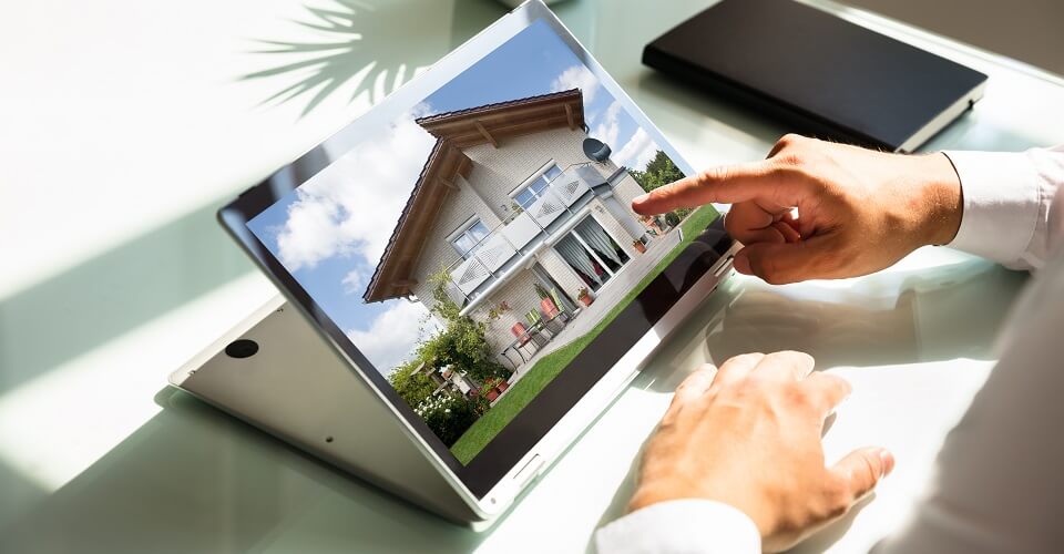 A man is looking at a property on a computer